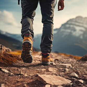 Man hiking, view of only his lower legs, rocks and tall mountains